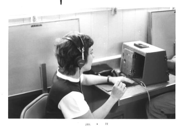 black and white photo of a woman taking a hearing test.  